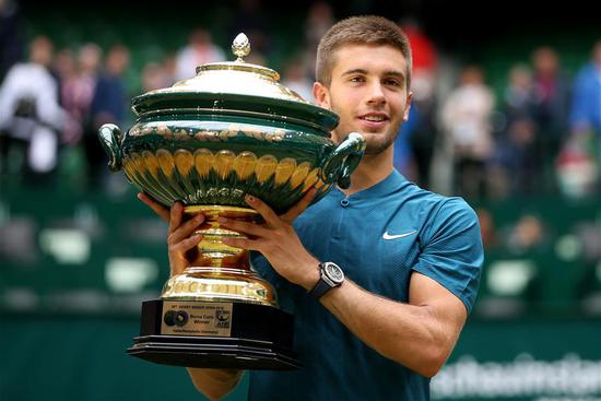 Borna Coric of Croatia lifts the trophy after winning the final match against Roger Federer of Switzerland at the Gerry Weber Tennis Open on June 24, 2018 in Halle, Germany. Borna Coric won 2-1. (Xinhua/Joachim Bywaletz)