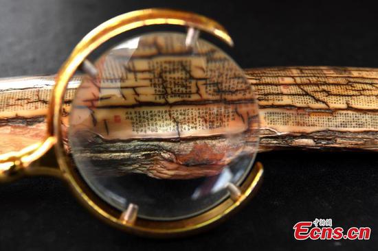 Magnifying glass needed to read tiny carved characters 