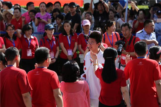 A candidate for this year's national college entrance exam, the gaokao, is cheered up by teachers and parents before entering an exam site in Beijing on June 7, 2018. (Photo by Wang Jing/chinadaily.com.cn)