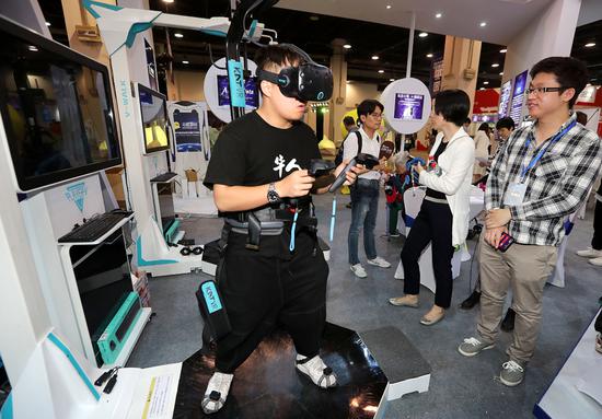 A visitor checks out a virtual reality headset at an exhibition for unicorns in Hangzhou, capital of Zhejiang Province. (Photo by Lin Yunlong/For China Daily)