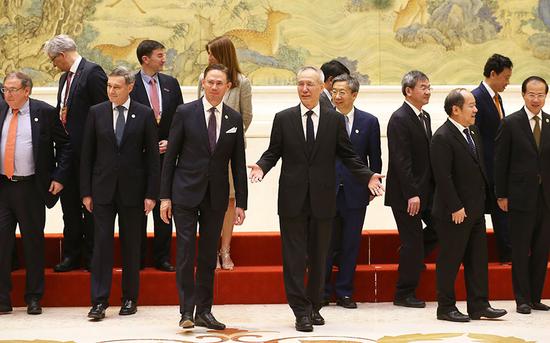 As they gather for a group photo at the Diaoyutai State Guesthouse in Beijing on Monday, Vice-Premier Liu He (center), European Commission Vice-President Jyrki Katainen (third from left in front row) and Chinese and EU officials attend the 7th China-EU High-level Economic and Trade Dialogue. (Photo by Zou Hong/China Daily)