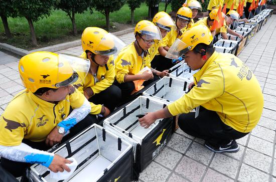 Employees of Meituan-Dianping prepare to make deliveries in Taiyuan, capital of Shanxi Province. ([Photo provided to China Daily)