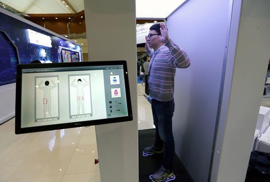 An exhibitor demonstrates a security scanner that uses millimeter wave imaging at a science and technology convention in Xi'an, Shaanxi province, last year. The technology was introduced recently for use in civil aviation in China. (Photo:  China News Service/Zhang Yuan)