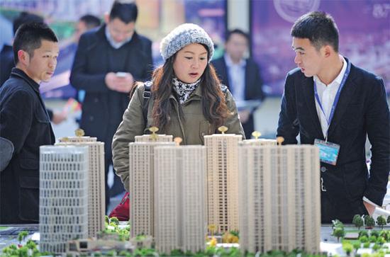 A model of housing development attracts the attention of visitors during a real estate expo in Hangzhou, capital of Zhejiang Province. (Photo provided to China Daily)