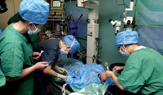 Volunteer surgeons from the charity operate on a patient aboard the train. (Provided To China Daily)