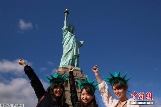 Women pose in front of the Statue of Liberty. (File photo/China News Service)