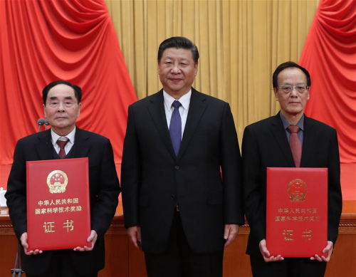 Chinese President Xi Jinping (C) poses for a photo with explosives expert Wang Zeshan (R) and virologist Hou Yunde, winners of China's top science award, at the National Science and Technology Award Conference in Beijing, capital of China, Jan. 8, 2018. (Xinhua/Ju Peng)