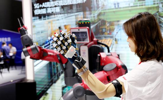 A technician demonstrates remote control of a smart robot supported by 5G services and artificial intelligence at a recent high-tech exhibition held in Shanghai. (Photo/XINHUA)
