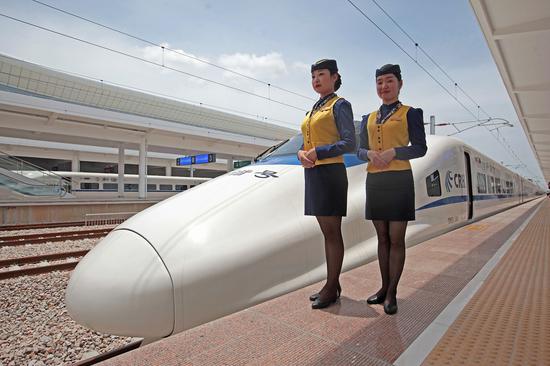 Two stewards stand by a CRH (China Railway High-speed) bullet train at Zhanjiangxi railway station in Zhanjiang, Guangdong Province. (Photo by Wu Weihong/For China Daily)