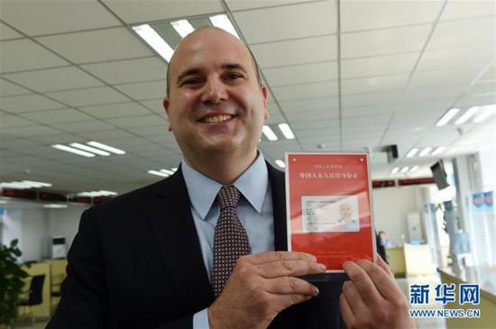 A foreigner shows his permanent residence identity cards in Beijing on June 16, 2017. [File photo: Xinhua]