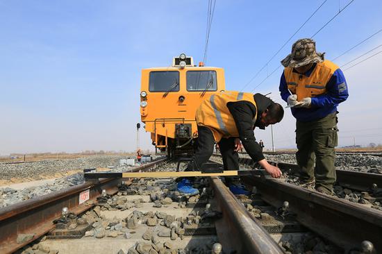 China Railway Harbin Group workers carry out maintenance work on the Harbin-Jiamusi high-speed railway line in May. (GUAN MINGYUE/FOR CHINA DAILY)