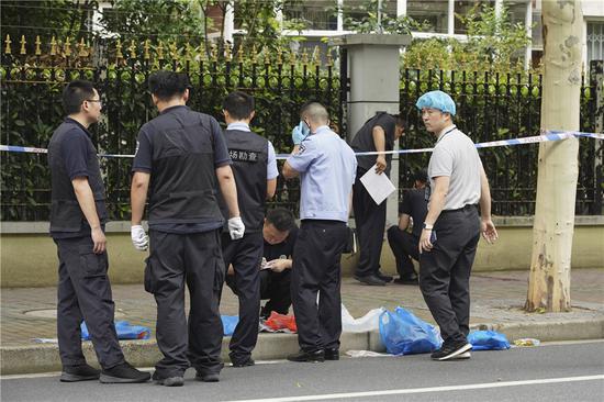 Police examine the site of a knife attack that occurred on Thursday morning in downtown Shanghai leaving two boys dead and another boy and a parent wounded. (Gao Erqiang/China Daily)