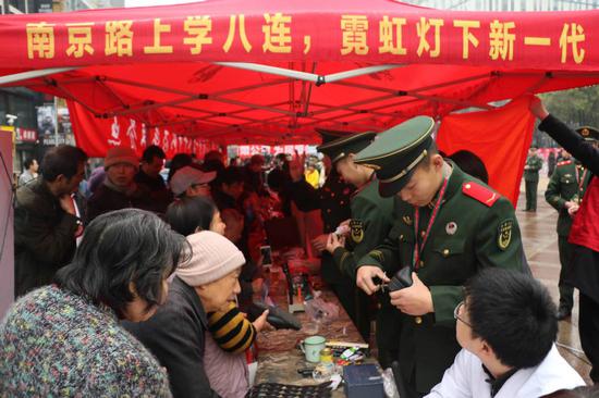 Soldiers of the squad provide voluntary services to Shanghai residents on the city's Nanjing Road. (ZHANG HAI/FOR CHINA DAILY)