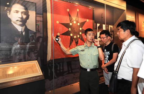 Li Haigang, a member of the People's Armed Police Force's Shanghai squad, guides visitors at the site of the Communist Party of China's First National Congress in Shanghai.  (ZHANG HAI/FOR CHINA DAILY)