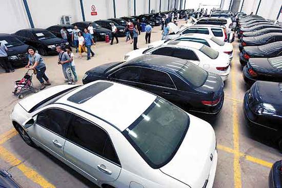 Customers look for cars at a used car market in Xi'an, Shaanxi Province. (Photo by Yuan Jingzhi/for China Daily)