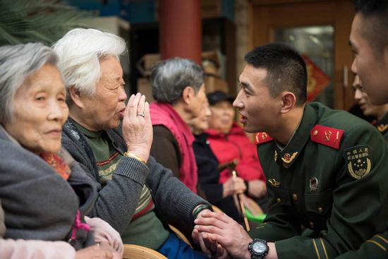 Members of the squad talk with residents of a nursing home in Shanghai during a regular visit. (ZHANG HAI/FOR CHINA DAILY)