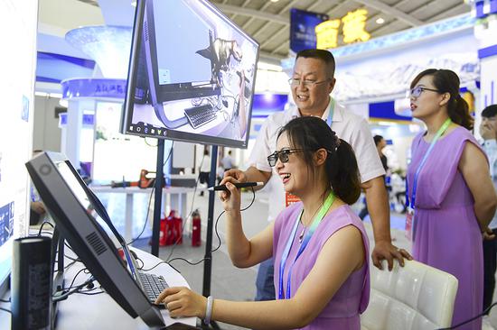 Exhibitors demonstrate virtual reality education materials during a tech exhibition in Shenyang, Liaoning province, on Wednesday. (An Chenhao/For China Daily)