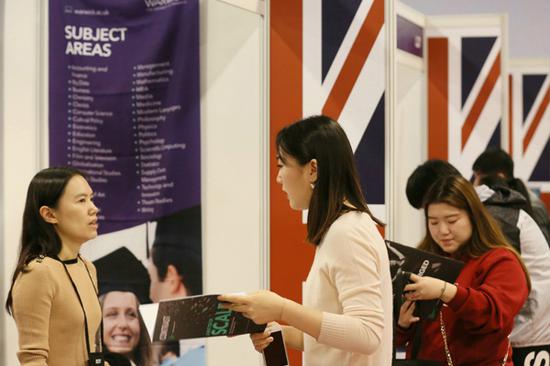 A visitor consults at the UK counter at China Education Expo in Beijing in October 2017. (Photo provided to China Daily)