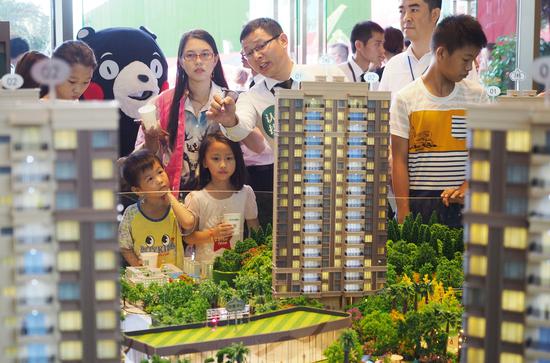 A property model attracts visitors during an industry expo in Dongguan, Guangdong province. [Photo by An Dong / For China Daily] 