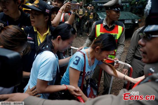 Family members are escorted by police on their way to enter the Tham Luang cave complex, as members of an under-16 soccer team and their coach have been found alive according to local media, in the northern province of Chiang Rai, Thailand, July 4, 2018. (Photo/Agencies)