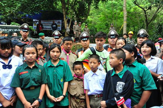 Photo taken on July 4, 2018 shows friends of the 12 trapped boys singing a song outside of a cave where 12 youth soccer players and their coach are trapped inside, in Mae Sai, Chiang Rai province, in northern Thailand.  (Xinhua/Rachen Sageamsak)