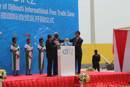 Bai Jingtao (left), general manager of China Merchants Group; Aboubaker Omar Hadi (center), the chairman of Djibouti Ports and Free Zones Authority; and Xu Jian (right), executive vice-president of Dalian Port, perform water blending ceremony to signify strengthening of relationship between the entities. They mixed sea water from China and Djibouti, during the launch of DIFTZ in Djibouti on July 5, 2018. (Photo by Edith Mutethya/China Daily)