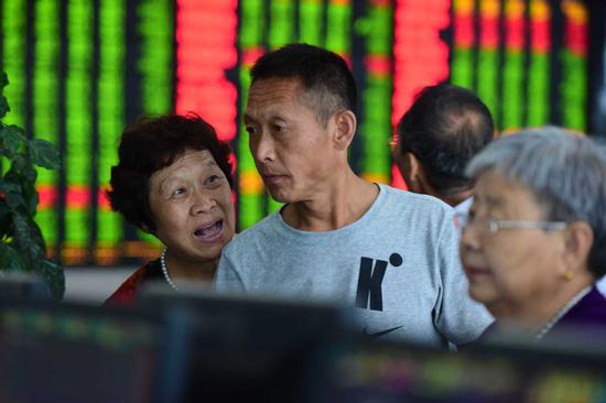Stock investors at a brokerage in Fuyang, Anhui province, on Friday. (Photo by Lu Qijian/For China Daily)