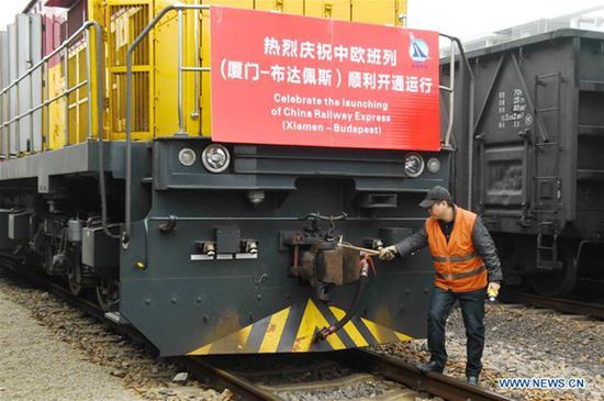 A staff member checks the freight train of China Railway Express (Xiamen-Budapest), linking southeast China's port city of Xiamen with Budapest, capital of Hungary, before its departure in Haicang Station in Xiamen, southeast China's Fujian Province, Jan. 19, 2018.  (Xinhua/Lin Shanchuan)