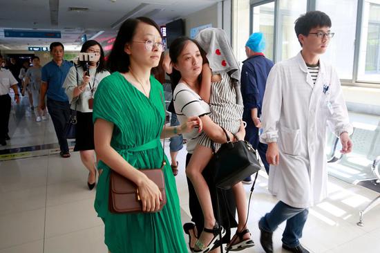 A young survivor of the boat tragedy in Thailand is carried into Haining People's Hospital in Haining, Zhejiang province, for a follow-up medical check. Six people from Haining who joined the tour group, including four who suffered minor injuries and two who chose not to board the boat, arrived home on Sunday. All were released. (Shen Zhicheng / For China Daily)