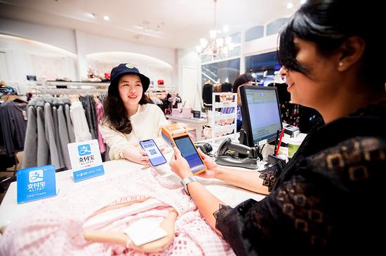 An outbound Chinese tourist pays with Alipay at the checkout of a shopping mall in Sydney. (Photo for China Daily by Xu Kangping)