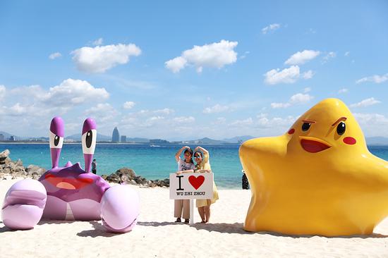 Two women pose for a photo at the beach of Wuzhizhou island in Sanya, Hainan Province. (Photo provided to China Daily)