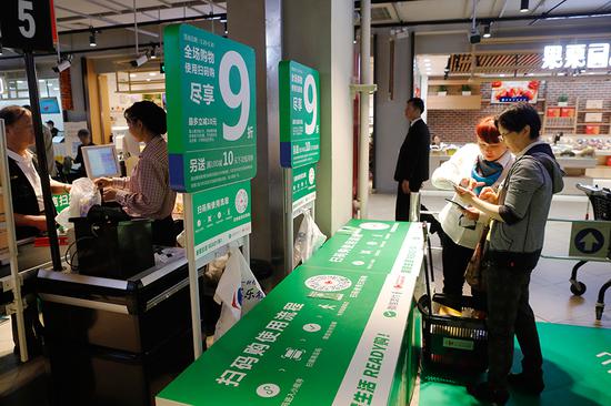 Shoppers buy goods at a Le Marche store in Shanghai, which was launched by Carrefour and Tencent in May. (Photo: China News Service/Yin Liqin)