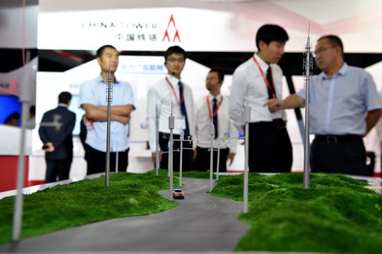 Visitors watch a model of Hainan Wanning informationalized expressway at the stand of China Tower at PT Expo China 2016, held in Beijing. (Photo: Xinhua/Li Xin)