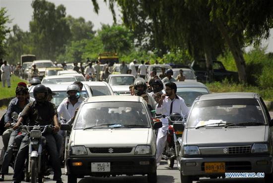 Vehicles and local residents are seen on road on World Population Day in Islamabad, capital of Pakistan on July 11, 2018. The World Population Day is observed on July 11 every year to raise awareness of global population issues.(Xinhua/Saadia Seher)