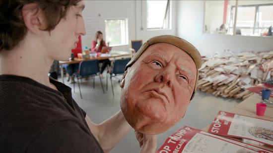 A protester puts the final touches on his Trump mask ahead of Friday’s demonstration. /CGTN Photo