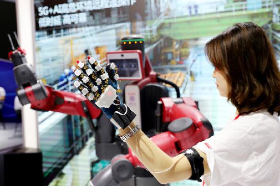 A technician demonstrates remote control of a smart robot supported by 5G services and artificial intelligence at a recent high-tech exhibition held in Shanghai. [Photo/Xinhua]