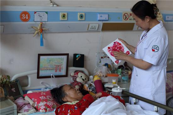  A member of staff at the Beijing Songtang Care Hospital, one of China's first end-of-life centers, chats with a patient.  (Photo: China Daily/Wang Jing)