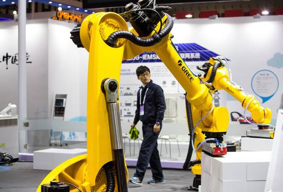 A robot grasps products at a booth of Gree Electric Appliances Inc at an expo in Nanjing, Jiangsu province. Shares of home appliance companies including Gree were popular targets of foreign investors in recent weeks. (Photo by LIU SONG/FOR CHINA DAILY)