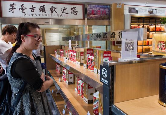 Customers select baijiu at a Kweichow Moutai store in Zunyi, Guizhou province. (Photo by CHEN YONG/FOR CHINA DAILY)