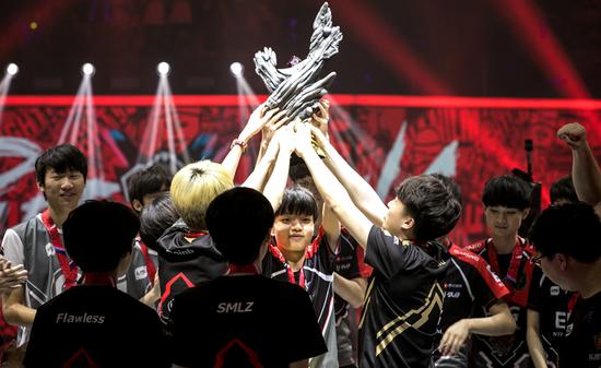 Players from the League of Legends Pro League hold the championship trophy at the tournament in Dalian, Liaoning province. (CHINA DAILY)