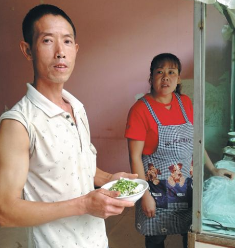 Xu Youxing (left) and his wife sell cold rice noodles and dumplings at their family-run snack bar in Danxia town of Panzhou, Guizhou province. (Photo by Jiang Xueqing/China Daily)