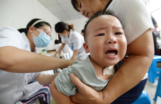 A child gets sanfutie－therapeutic bandages filled with herbal medicine placed at acupuncture points－at Handan Traditional Chinese Medicine Hospital in Handan, Hebei province, on Tuesday. It was the first day of sanfu, the dog days of the summer. In TCM practice it is considered a particularly suitable time for treating illnesses. (HAO QUNYING/FOR CHINA DAILY)