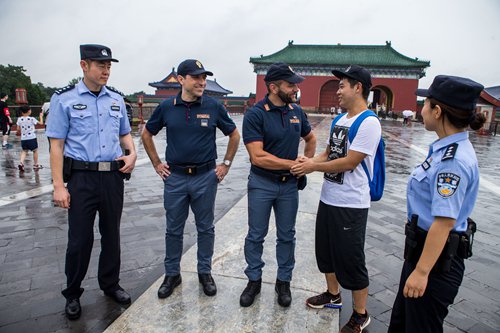 A Chinese tourist shakes hands with an Italian policeman at the Tiantan, better known as the Temple of Heaven in Beijing on Tuesday. （Photo: Lihao/ GT）