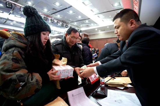 Wang Xiangjie, a judge from Dongcheng District People's Court, returns assets to people who have applied to settle their debts. (Photo/CHINA DAILY)