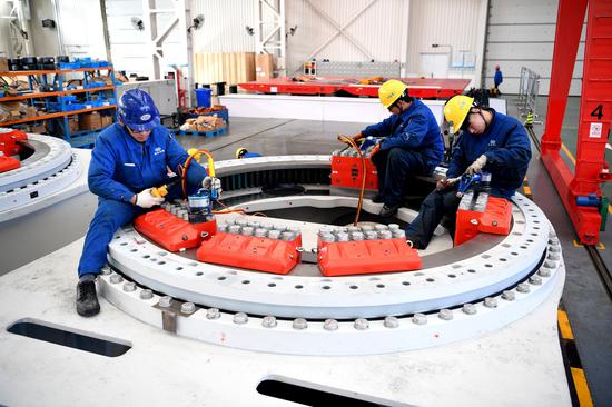 Employees from a subsidiary of China Shipbuilding Industry Corp install clean-energy equipment in Nantong, Jiangsu Province. (Photo/Xinhua)