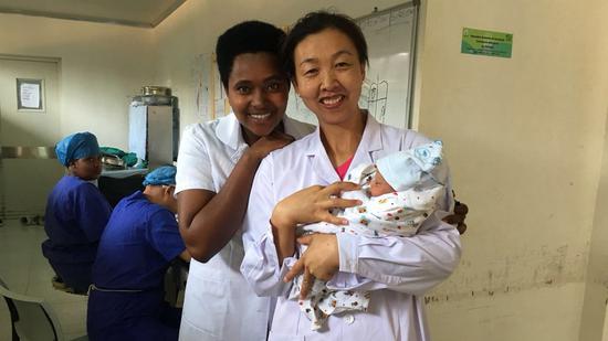 Lu Jun (R) with a newborn baby. /Photo provided by Lu Jun