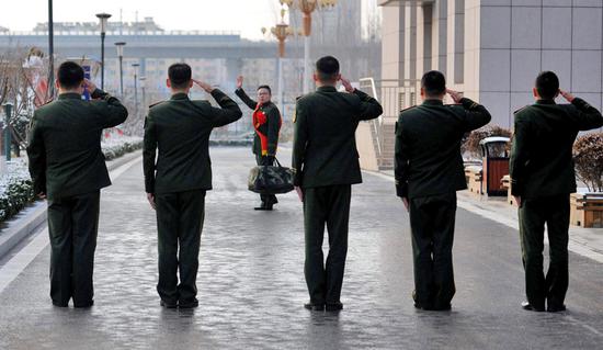 Soldiers from a branch of the border defense forces in Yantai, Shandong province, see off a demobilized soldier. (TANG KE/FOR CHINA DAILY)