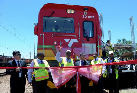 Staff members cheer the launch of CRRC Zhuzhou Locomotive Co Ltd's electric locomotives in Pretoria, South Africa. (Photo/Xinhua)