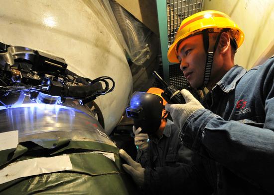 A technician oversees an automatic welding operation at the Ningde nuclear power station in Fujian Province. (Photo/Xinhua)