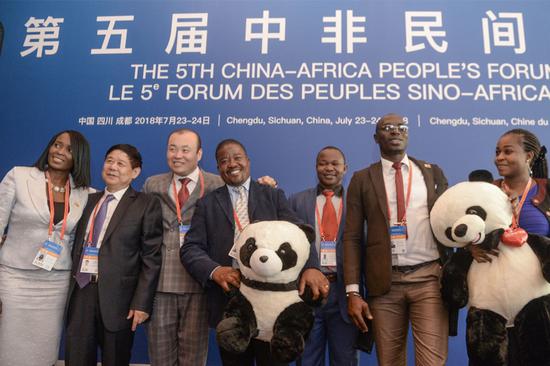 Participants of the China-Africa People's Forum hold toy pandas for a group photo on Monday in Chengdu. (HAO FEI/FOR CHINA DAILY)